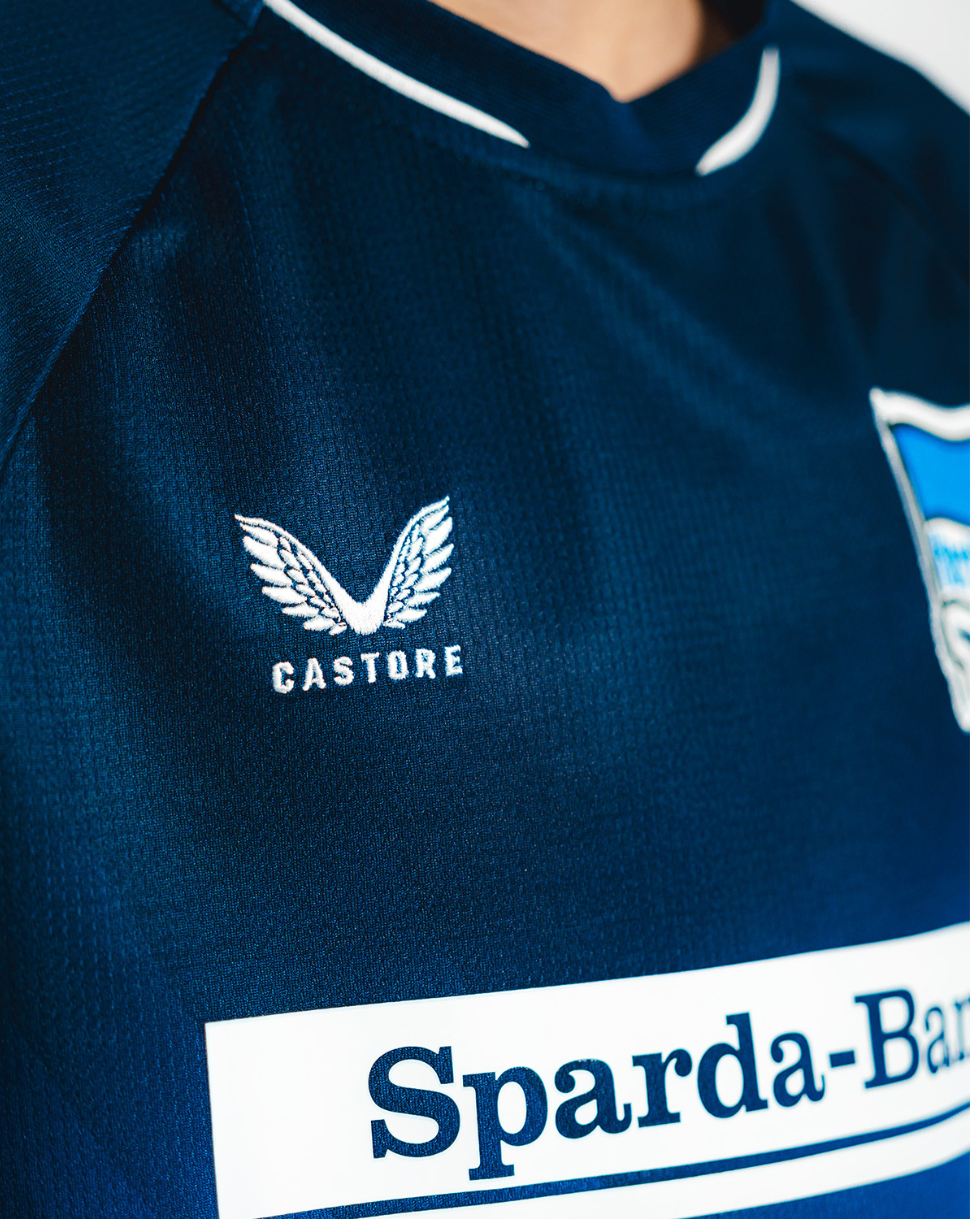 Close-up of navy jersey chest showing Castore logo and Hertha BSC crest