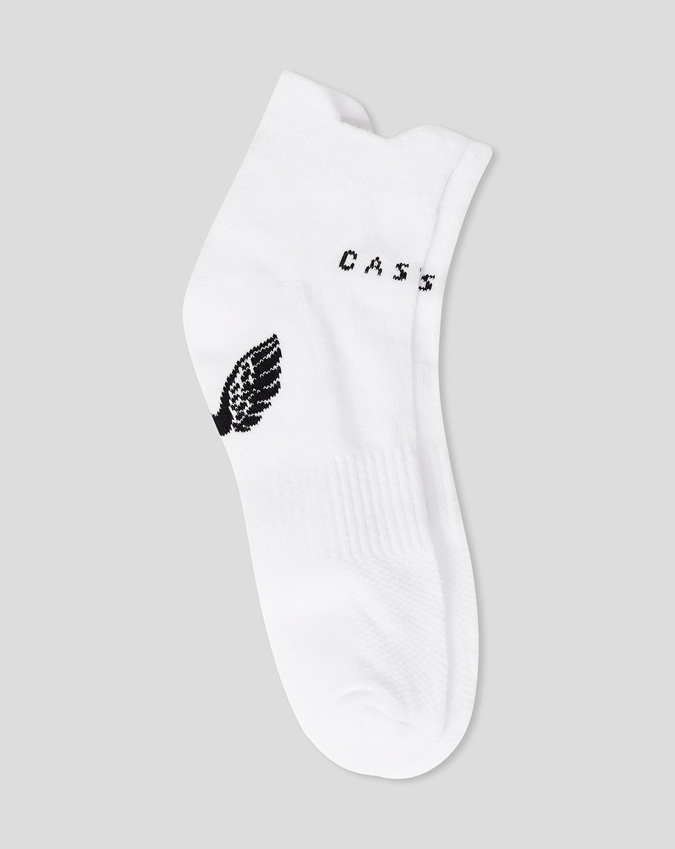 Close up of white Cushioned Ankle Sock with ribbed cuff and visible black branding.