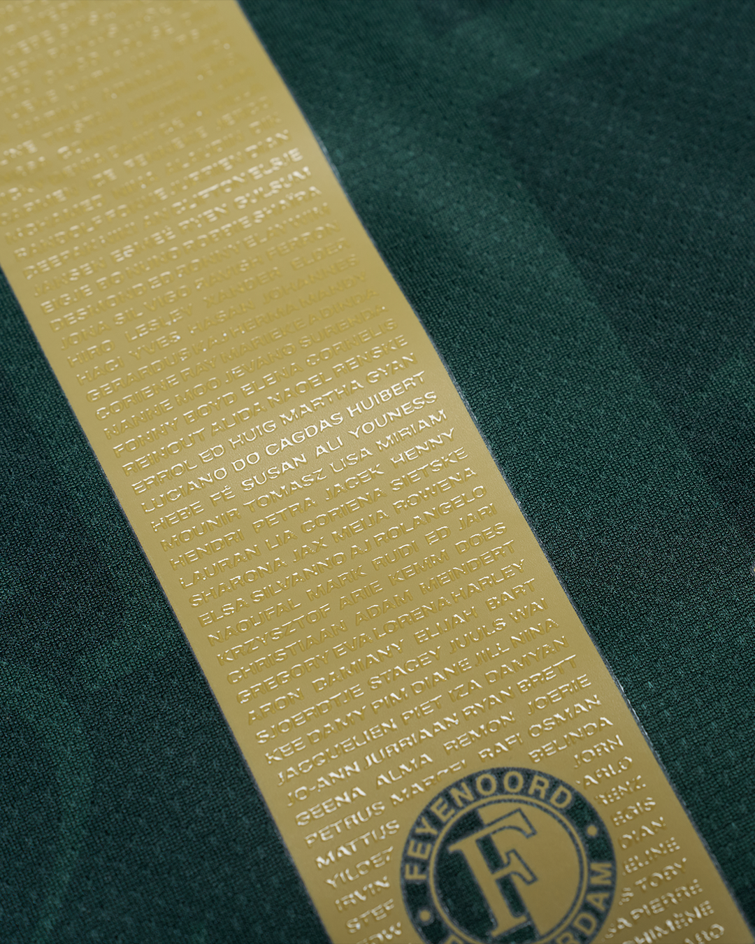 Gold name ribbon with numerous embossed names and Feyenoord crest on dark green shirt