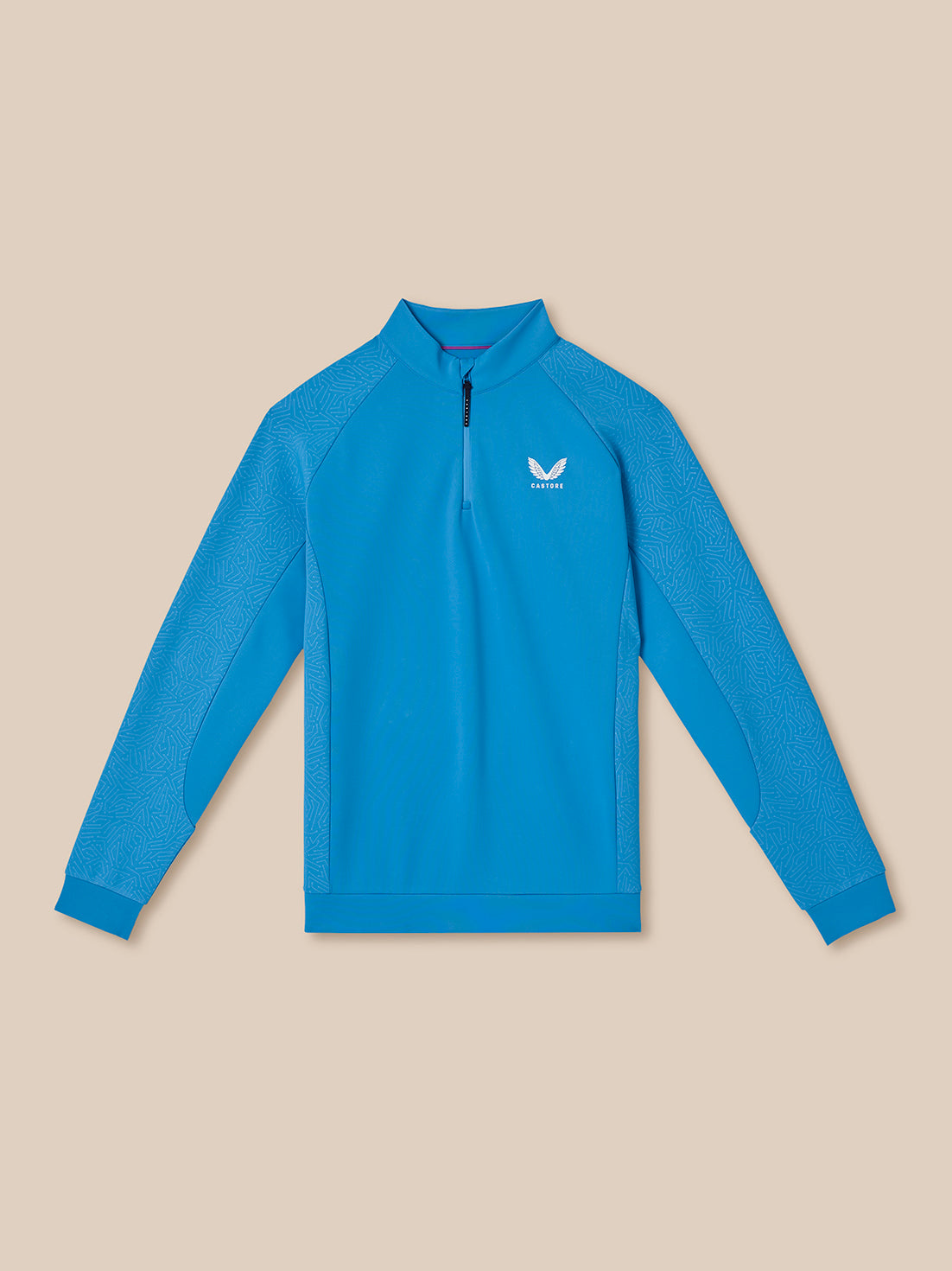 Blue long-sleeve golf quarter zip top with Castore logo on a beige background