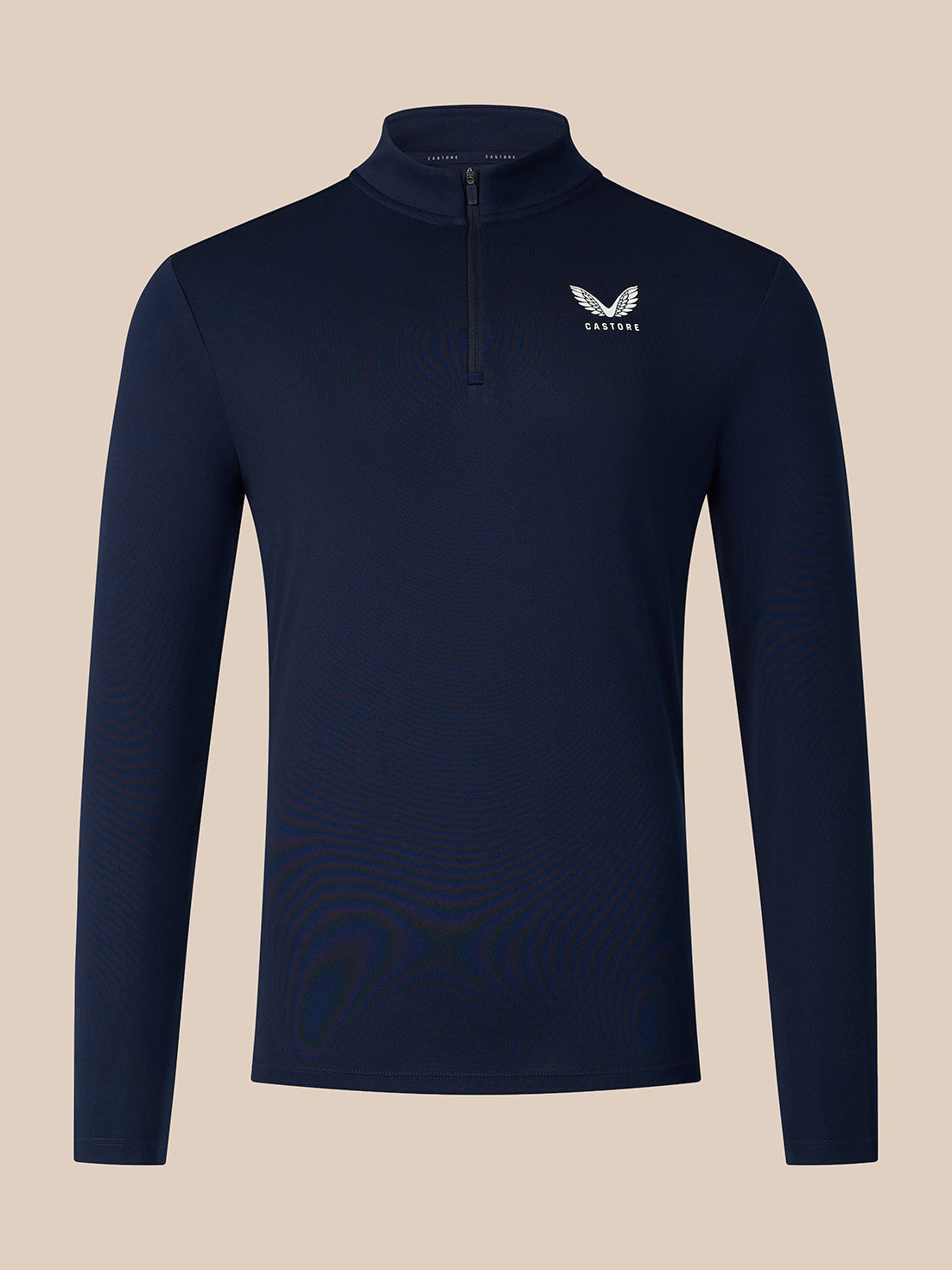 A navy blue long-sleeve quarter-zip pullover with a small white winged logo and the word 'CASTORE' on the left chest, displayed against a solid beige background.