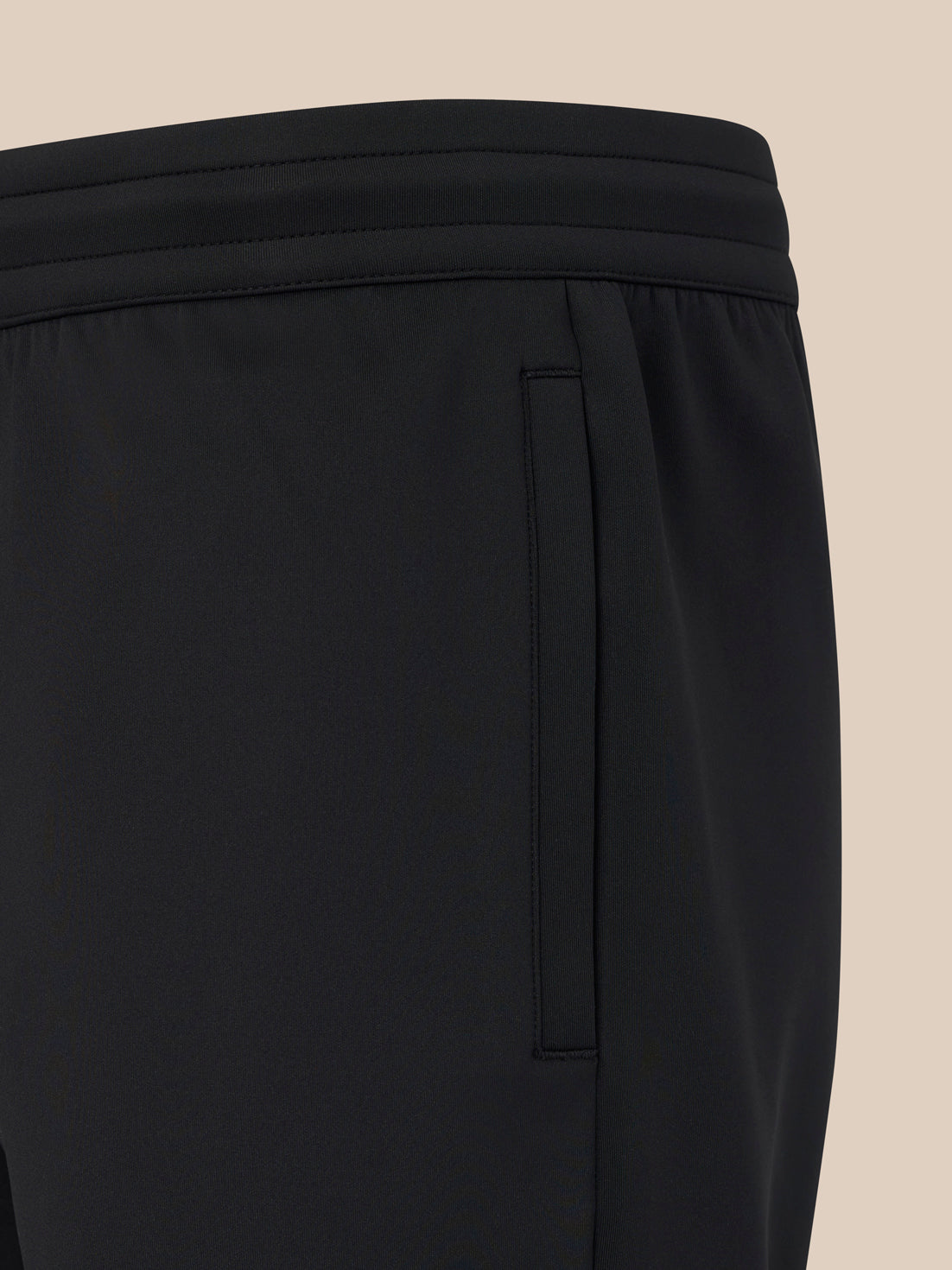 Close-up of black pants on a beige background