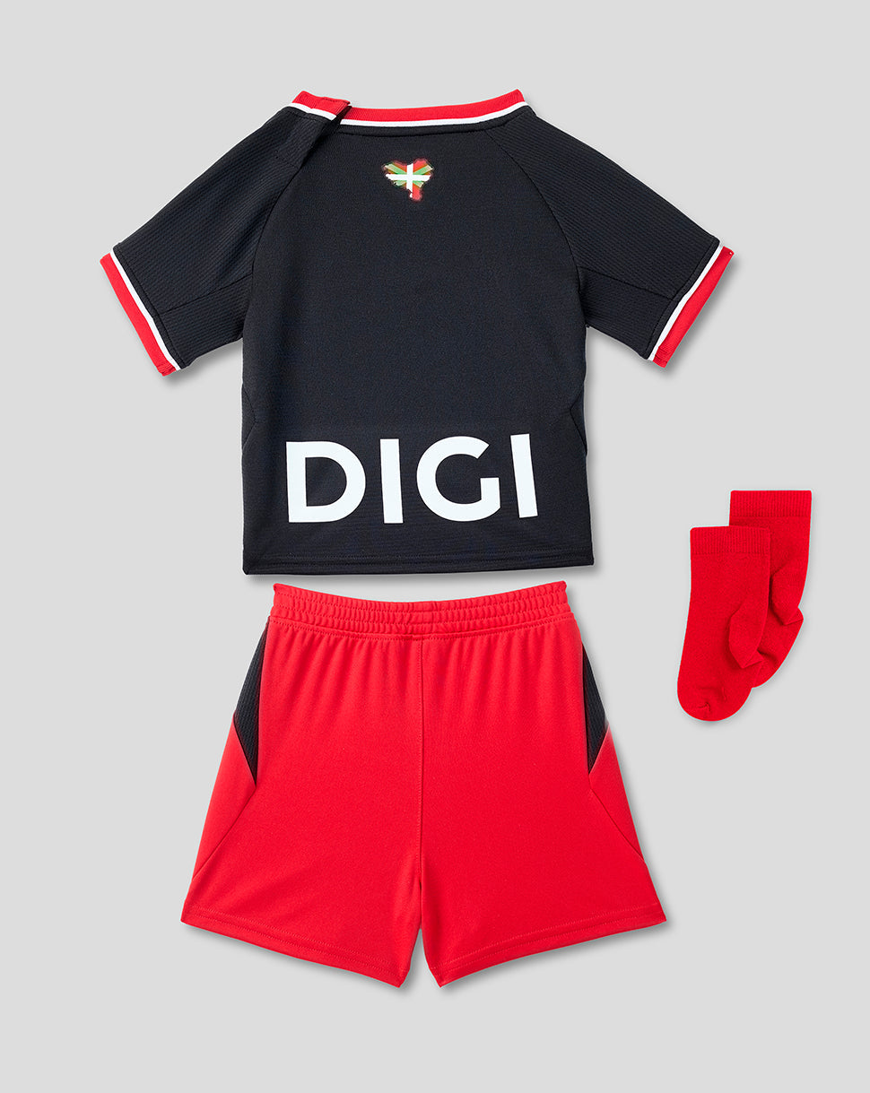 Back view of the infant away kit showing a black jersey with a large DIGI logo, paired with red shorts and red socks