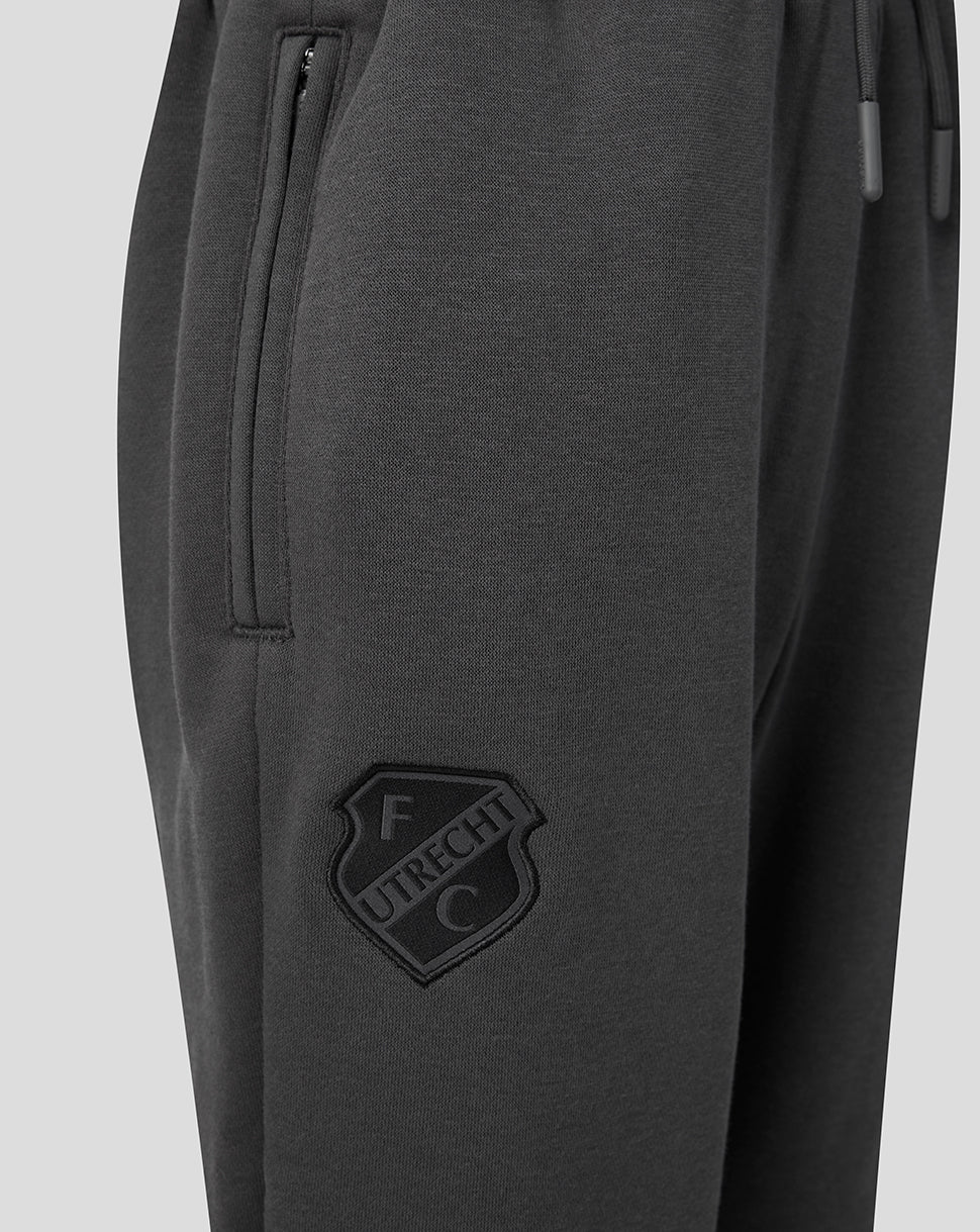 Close-up of dark grey FC Utrecht travel fleece pants showing a zippered side pocket and the FC Utrecht crest on the leg