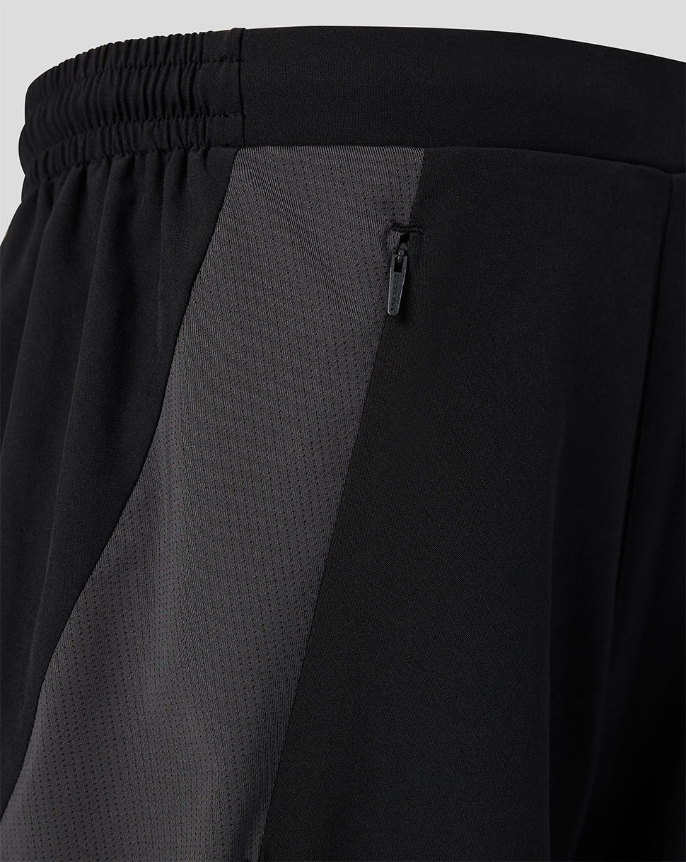 Close up of black FC Twente junior training shorts showing a gray side panel and zip pocket.