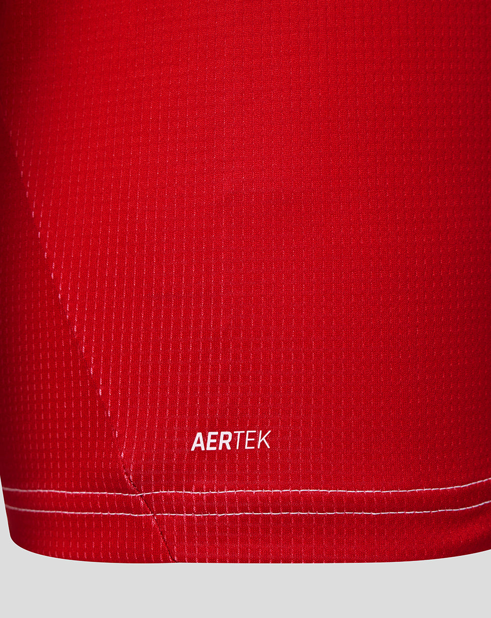 Close-up of red Feyenoord junior home shirt fabric with an AERTEK ventilation badge