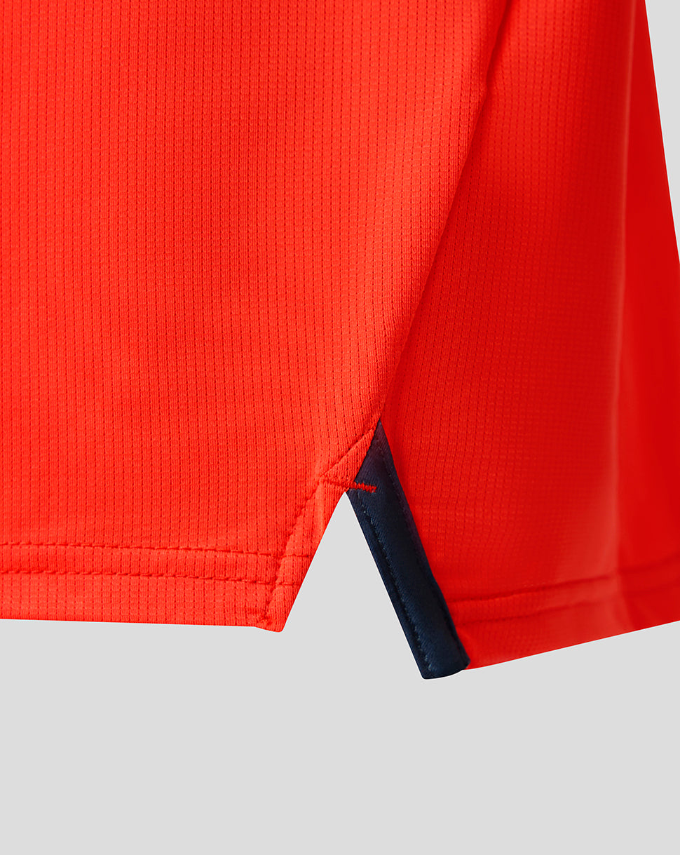 Close-up of bright orange Feyenoord Junior third matchday shirt with navy side slit trim