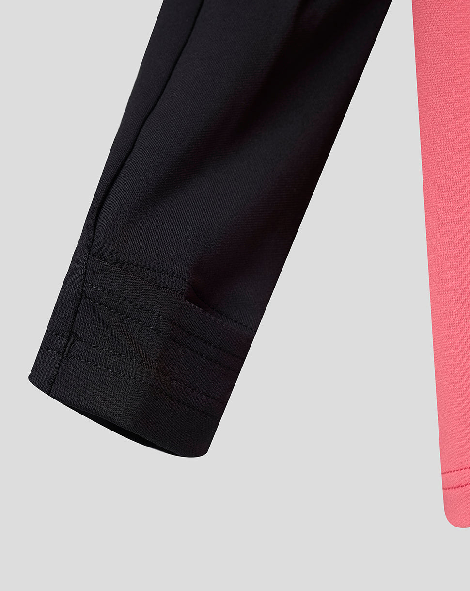 Close-up of black pants with a pink fabric edge on a light gray background