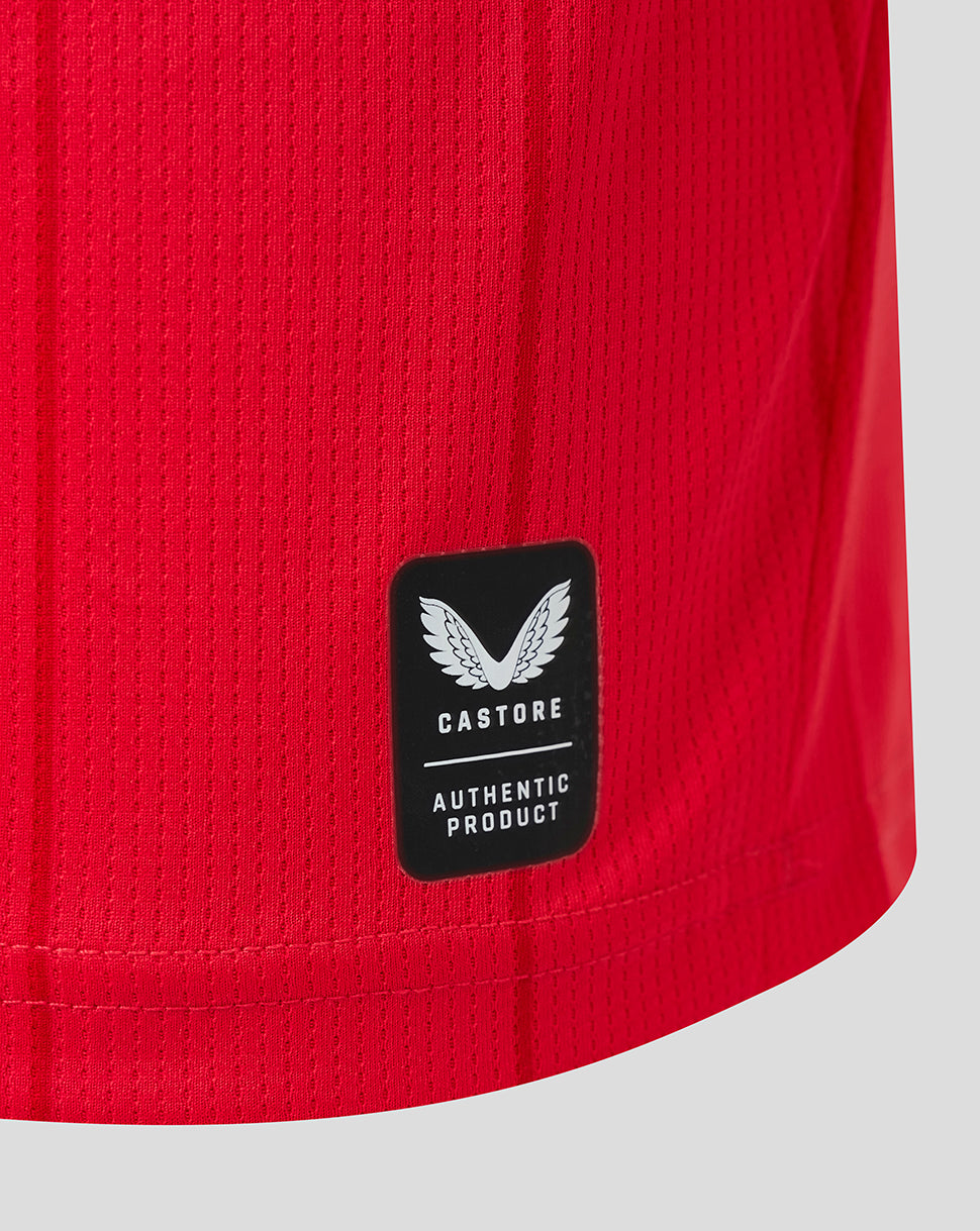 Red FC Twente junior home shirt fabric with Castore authentic product patch.