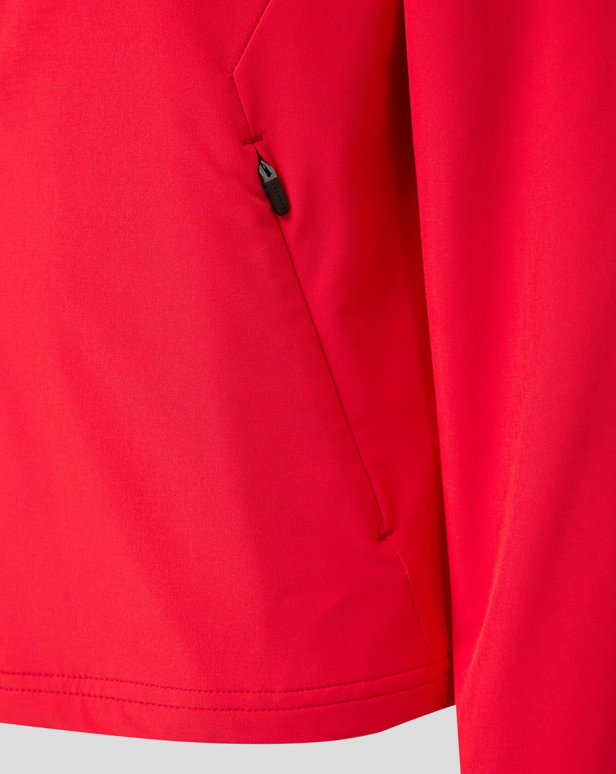 Close-up of red FC Twente junior matchday jacket fabric with a small zipper pull