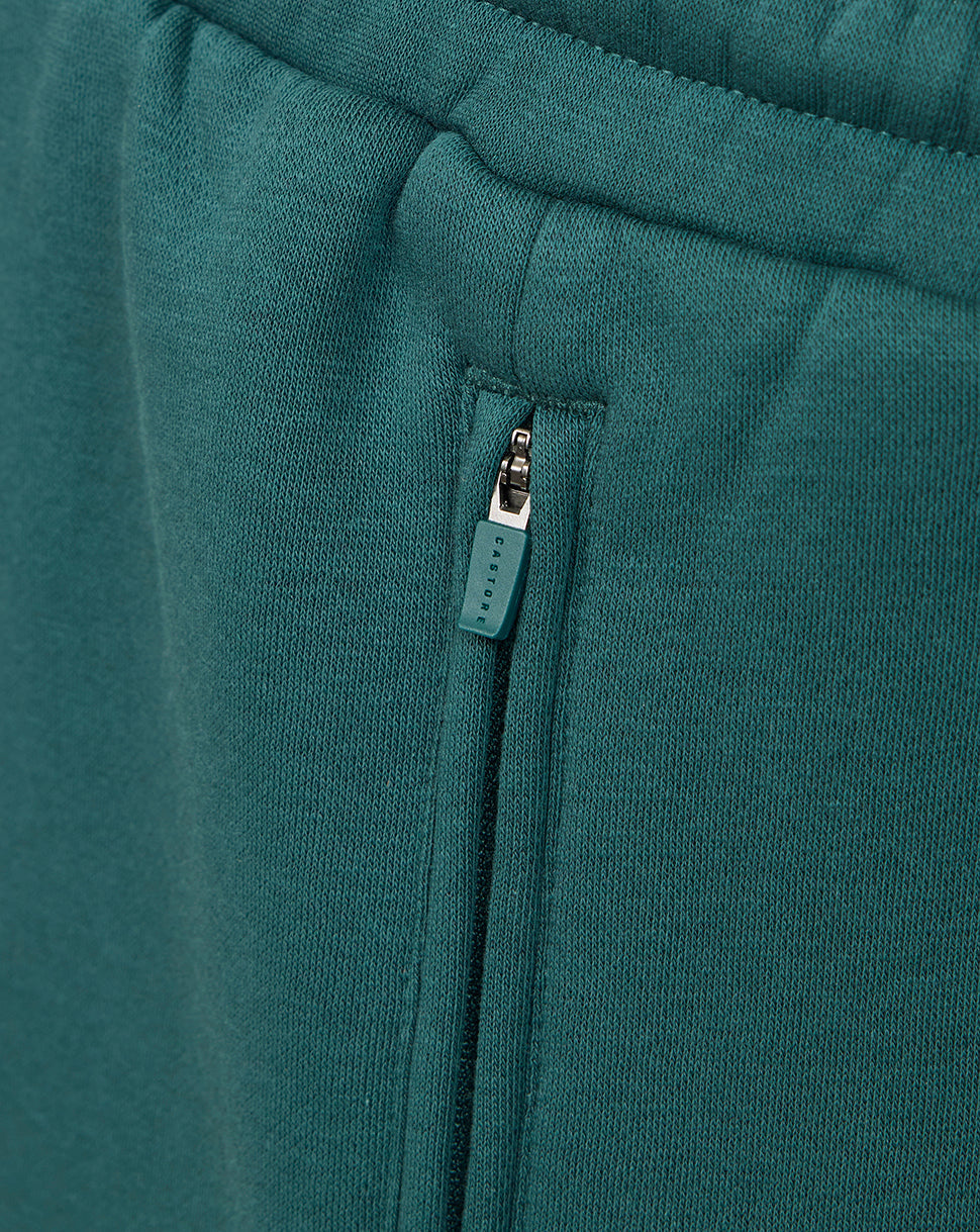 Close up of teal shorts zip pocket with Castore branded pull.