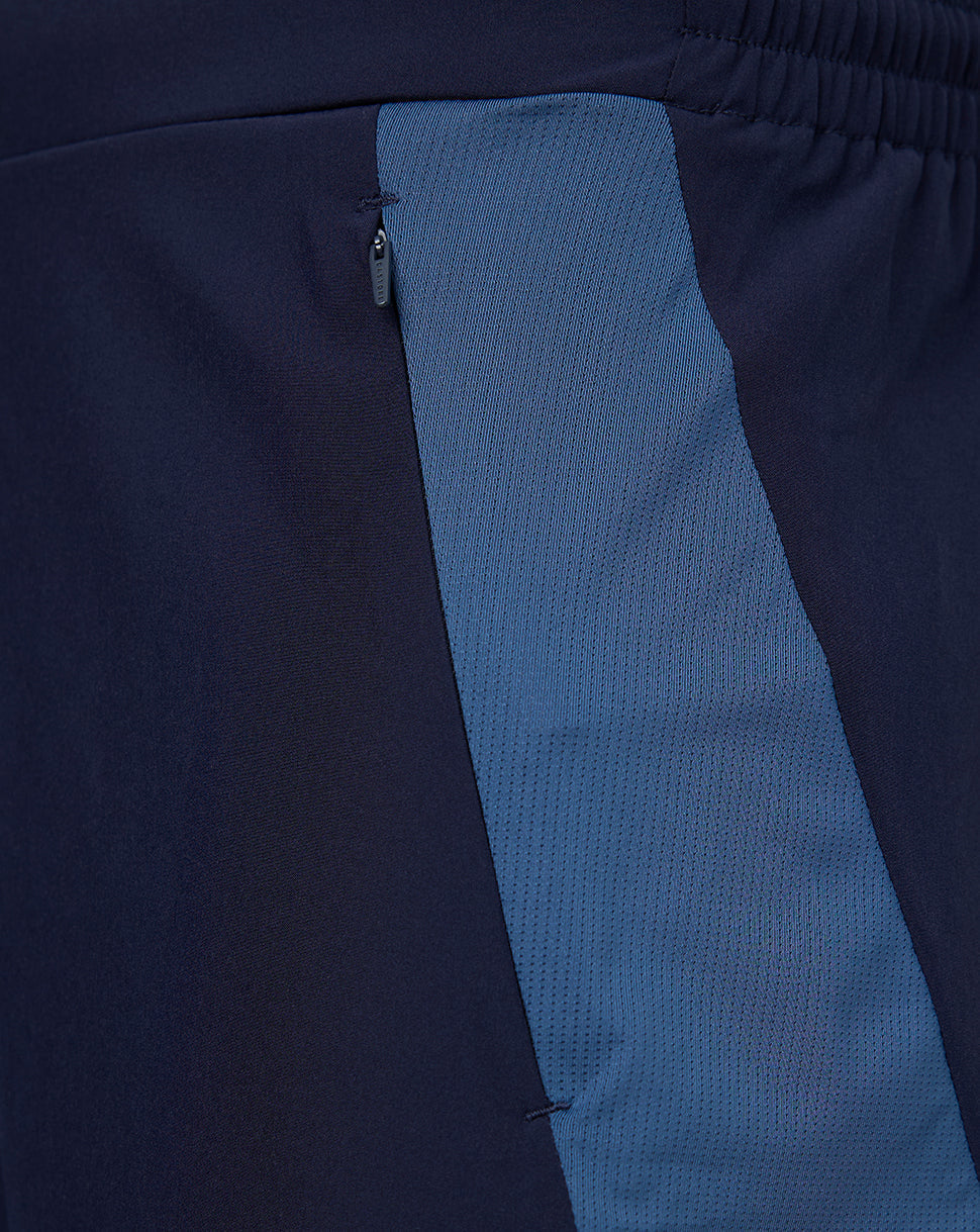 Close up of navy training shorts showing a blue side panel and a small zipper pocket.