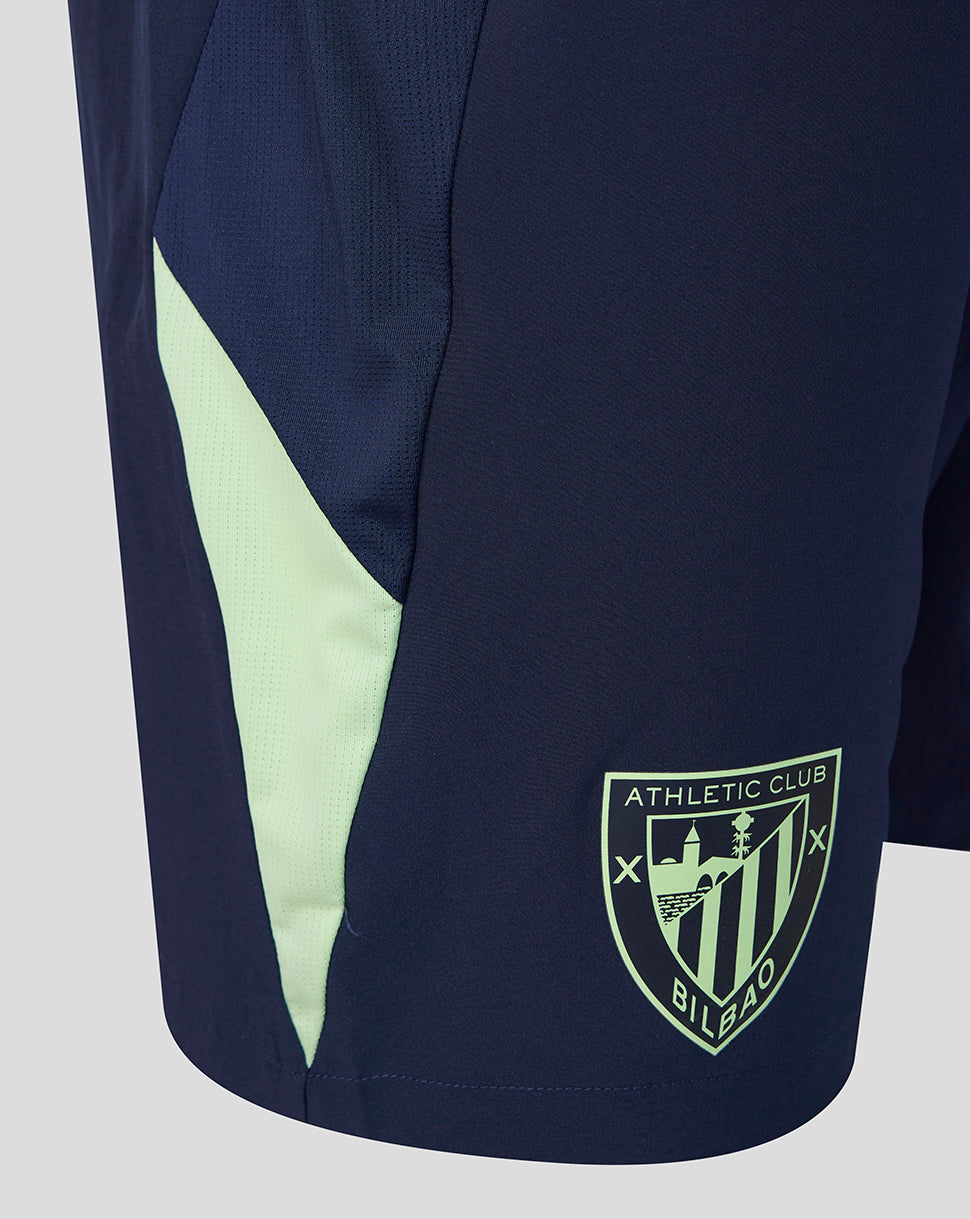 Side view of navy shorts with a pale green panel and Athletic Club crest