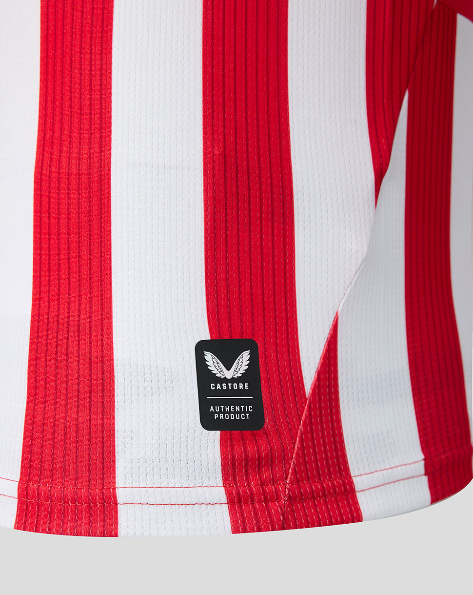 Close up of red and white striped junior home shirt with Castore authentic product patch
