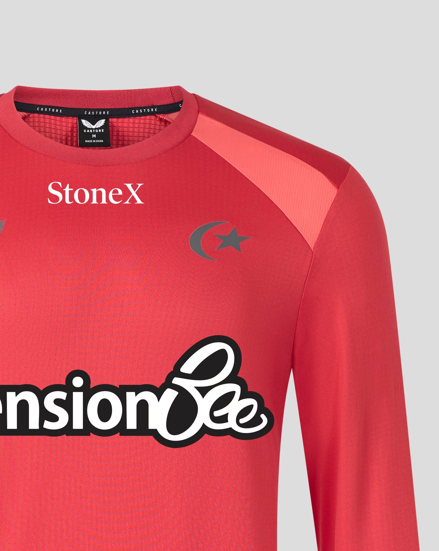 A close-up of a red long-sleeve athletic jersey with 'StoneX' printed on the chest, a dark gray crescent and star logo, and a visible neck label for 'Santoso'.