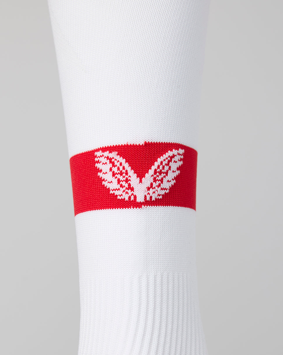 Close-up of white Athletic Club footless sock with a red band and white crest.