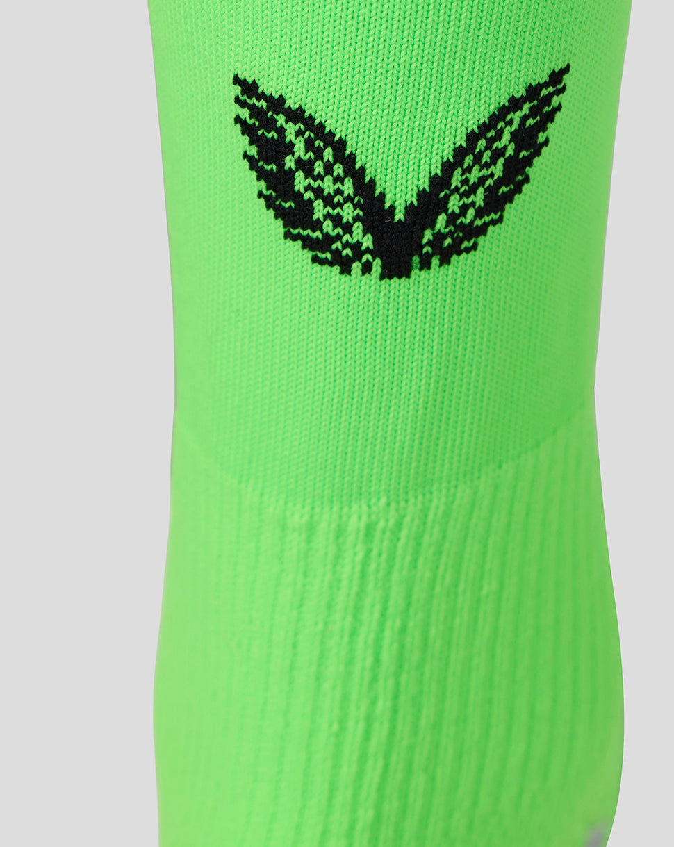 Neon green goalkeeper sock close-up featuring a black Castore logo