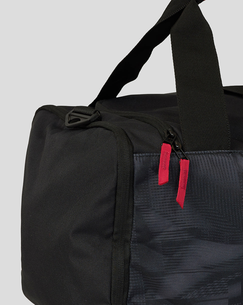 Black duffel bag with a red tag on a light gray background