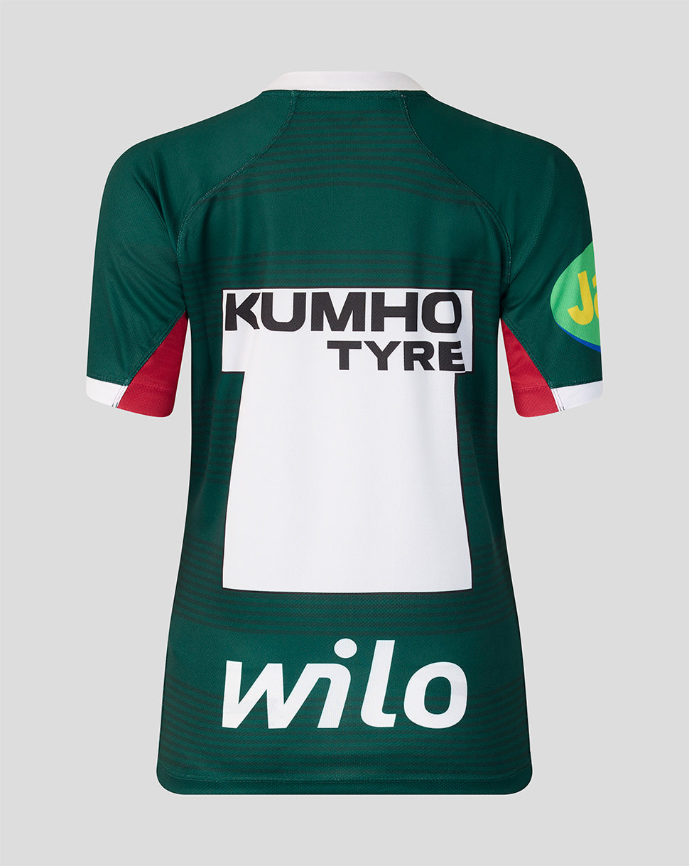 Back view of a dark green rugby jersey with a large white back panel, red sleeve accents, and sponsor logos including KUMHO TYRE, wilO, and a JBL patch.