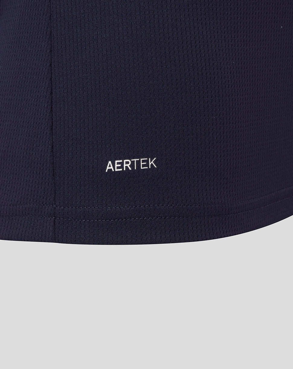 Close-up of AerTek logo on navy fabric near the hem of the shirt