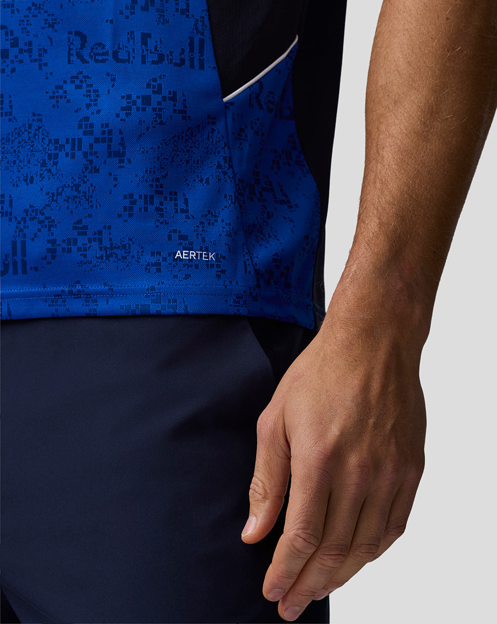 Close-up of a person wearing a blue and black patterned shirt with 'Red Bull' branding.