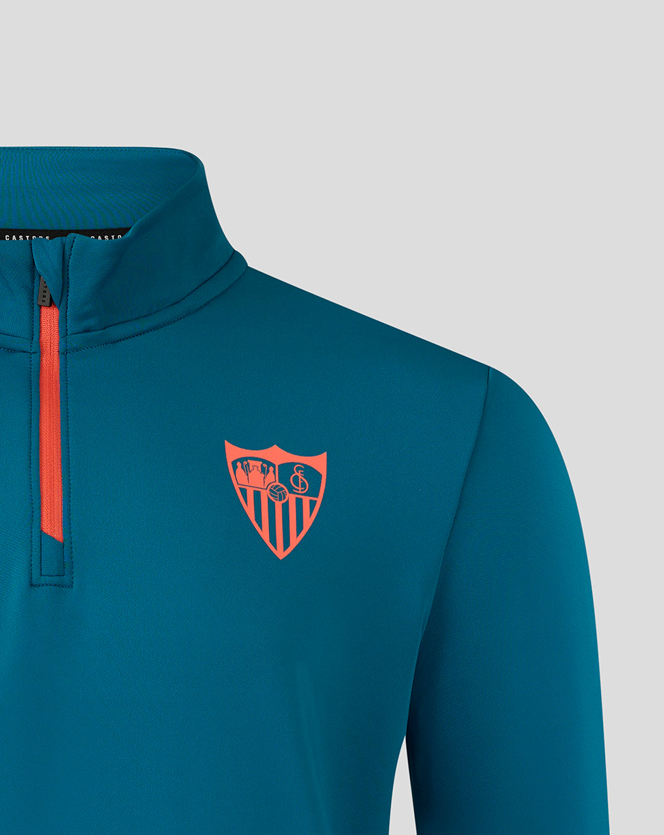 Shoulder and chest detail of teal ink blue Sevilla top with orange zipper and crest logo