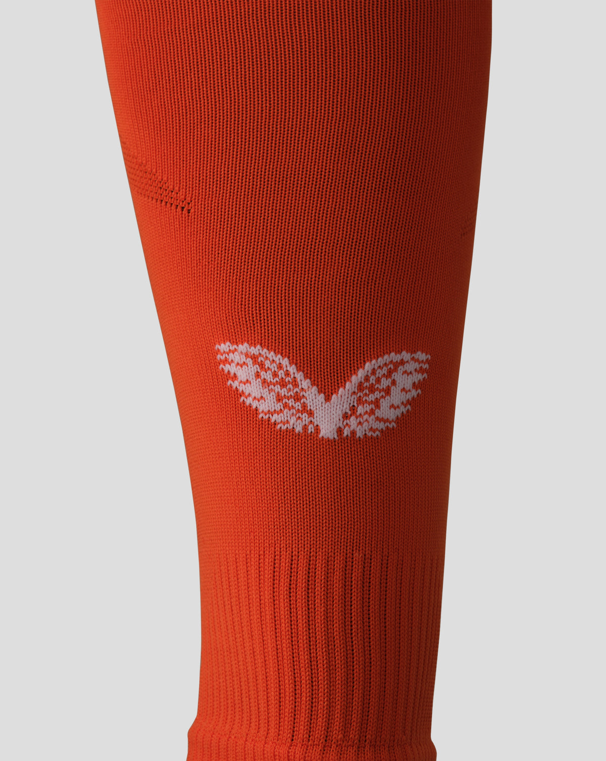 Close up of bright orange Feyenoord away goalkeeper sock knit with a white logo near the bottom