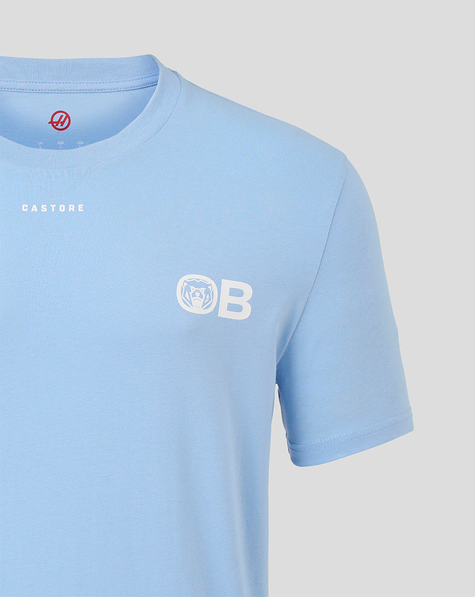 A light blue short-sleeve crewneck t-shirt by Castore, featuring a white 'OB' logo with a bear head emblem on the left chest and 'CASTORE' printed in white on the right chest, shown against a neutral light gray background.