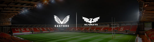 Castore and Scarlets partnership banners over a rugby stadium at night