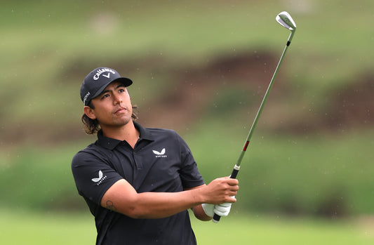 Malaysian golfer Gavin Green in Castore cap and polo during a practice swing.