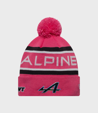 Pink knit cuff beanie with fluffy pom pom and Alpine branding on the cuff
