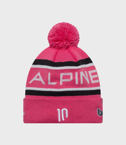 Pink knit beanie with a fluffy pom pom and Alpine branding on the cuff