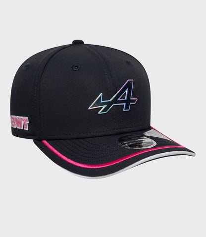 Left side view of navy cap with pink edge trim on the brim and holographic emblem on the crown