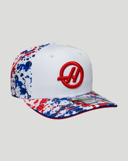 White cap with red and blue splatter design on a white background