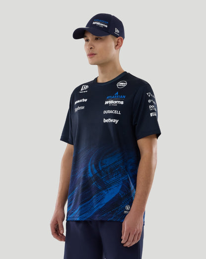 Model wearing navy Williams Racing 2026 F1 Team T Shirt with Atlassian Williams logo left chest and New Era flag right chest