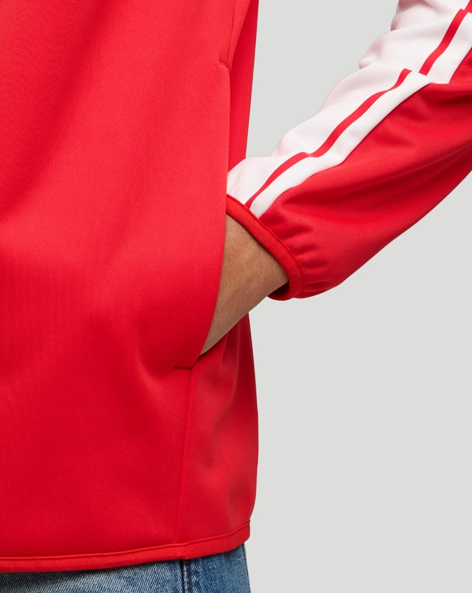 Detail of the red jacket sleeve with a white stripe, cuff, and visible side pocket.
