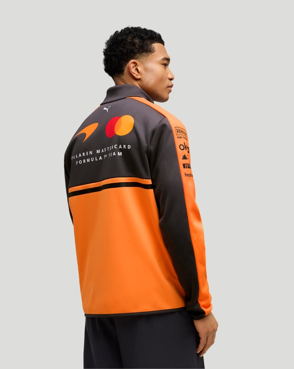 Back view of a McLaren Mastercard F1 Team jacket in orange and dark gray with branding.