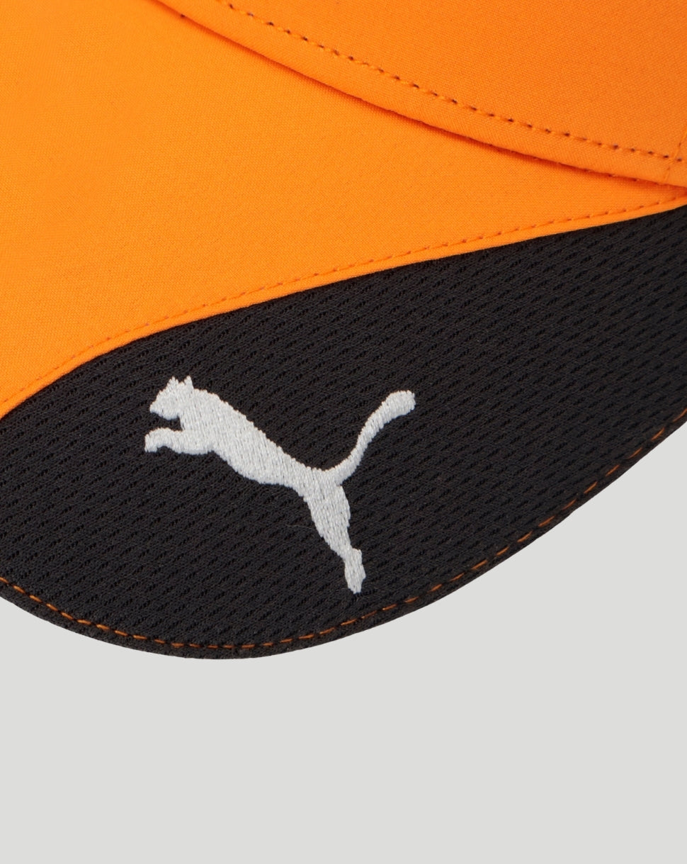 Close up of curved black cap brim with white Puma logo against bright orange cap fabric.