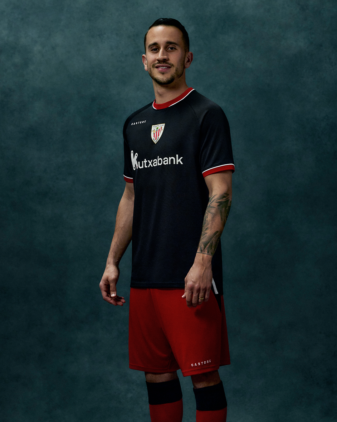 Athletic Club 26/27 away shirt in black with red collar and sleeve trim worn by a man; crest and Kutxabank logo.