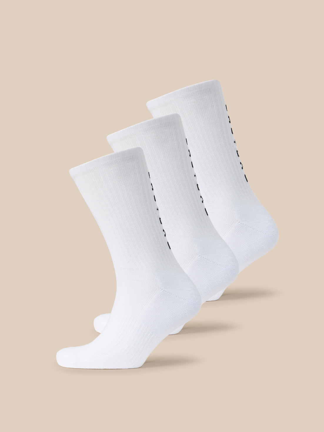 Three white Castore X Paynter crew socks with black branding along the side