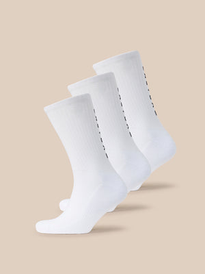 Three white Castore X Paynter crew socks with black branding along the side
