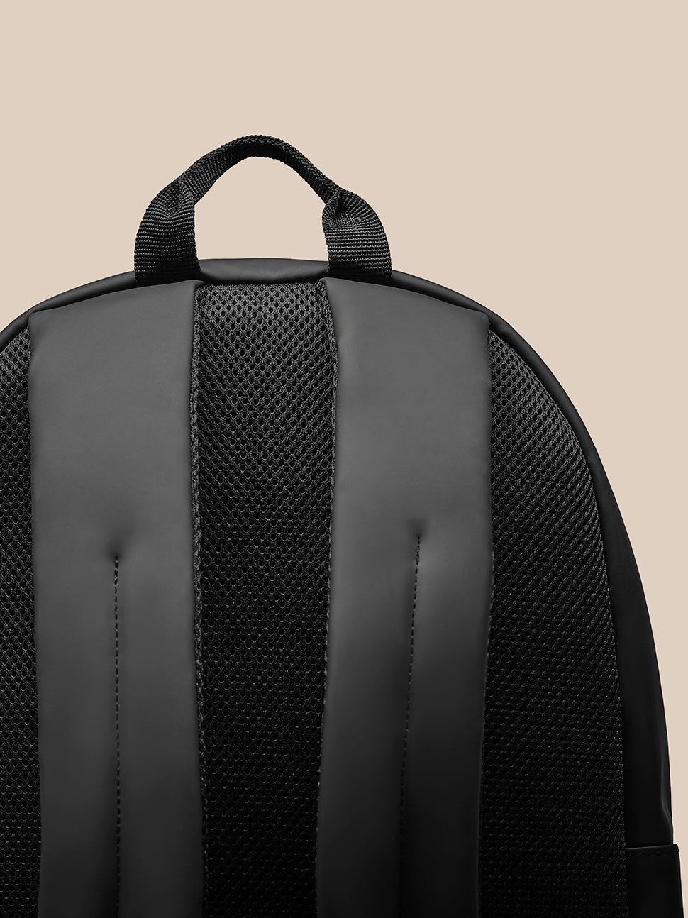 Close-up of the navy Core Backpack top handle and padded shoulder straps