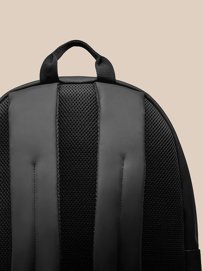 Close-up of the navy Core Backpack top handle and padded shoulder straps
