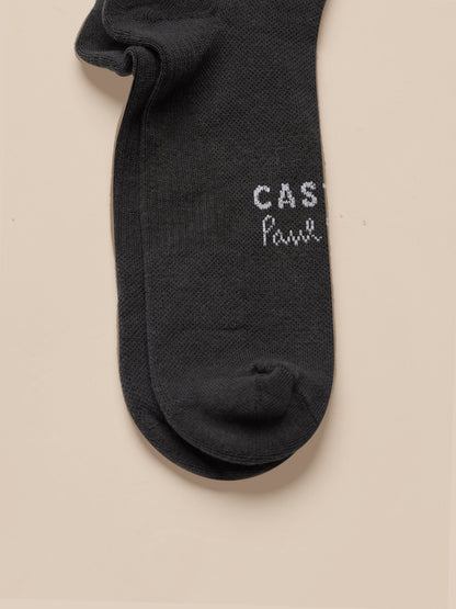 Black sock with 'CASTORE Paul Smith' text on a beige background