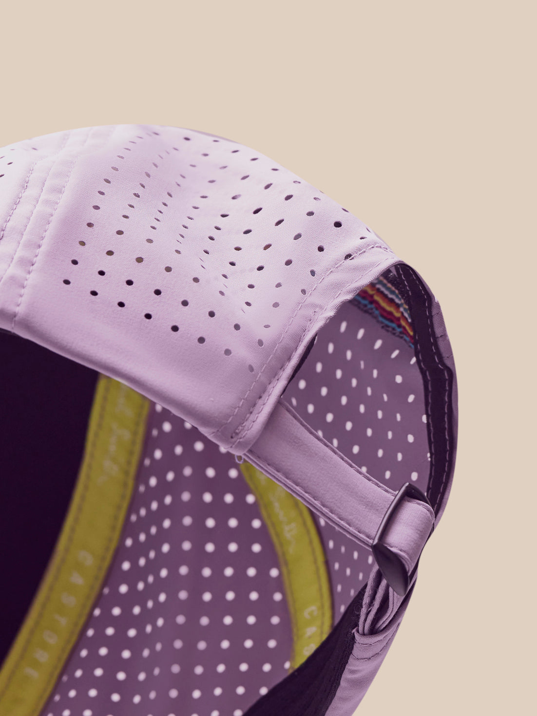 Close-up of a purple cap with a yellow interior on a beige background