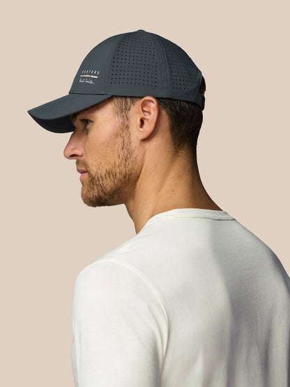 Man wearing a dark grey cap with a visible brand logo on a beige background