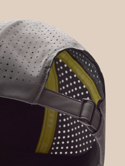 Close-up of a gray cap with a black strap on a beige background