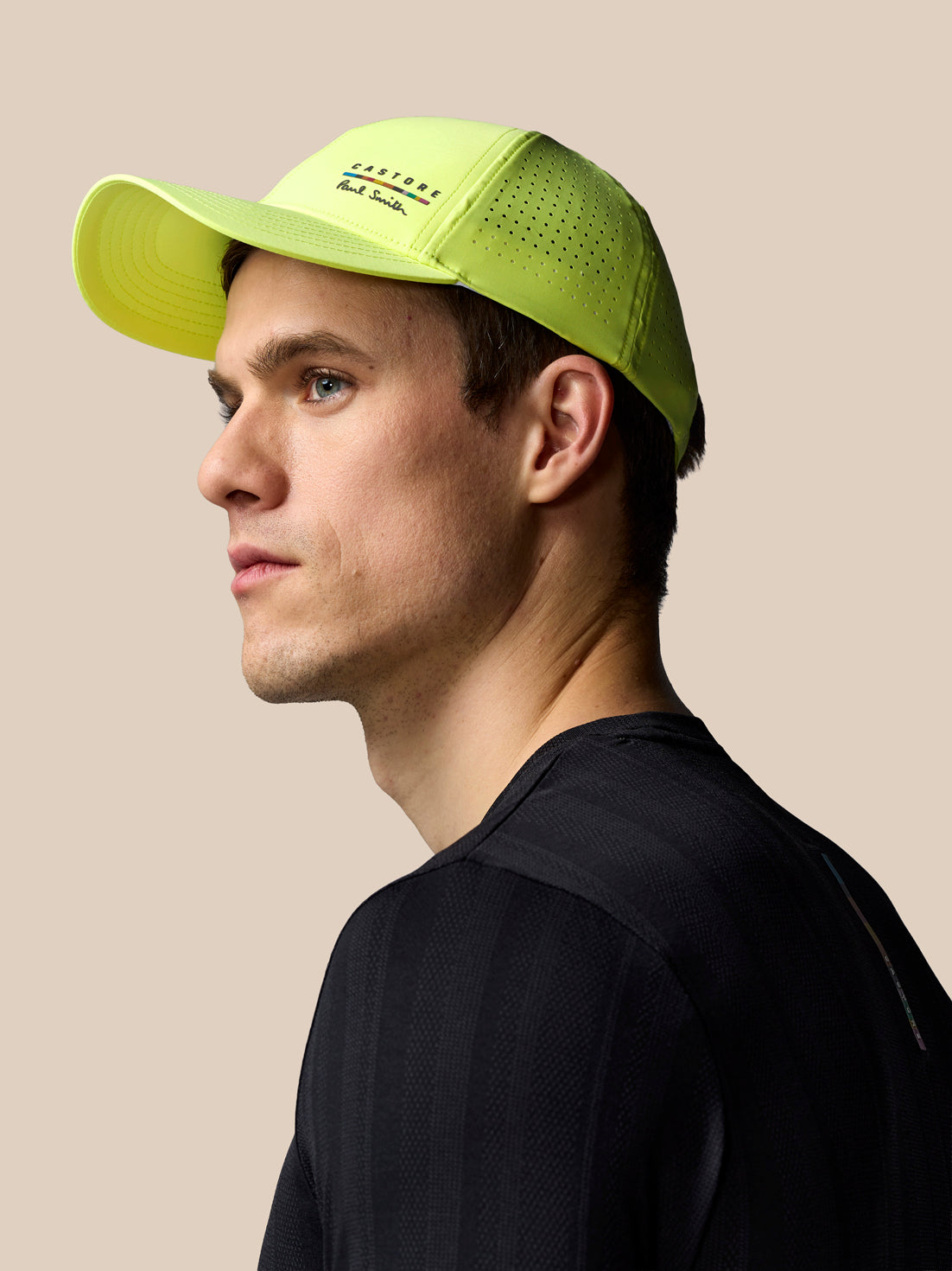 Man wearing a bright green cap on a beige background