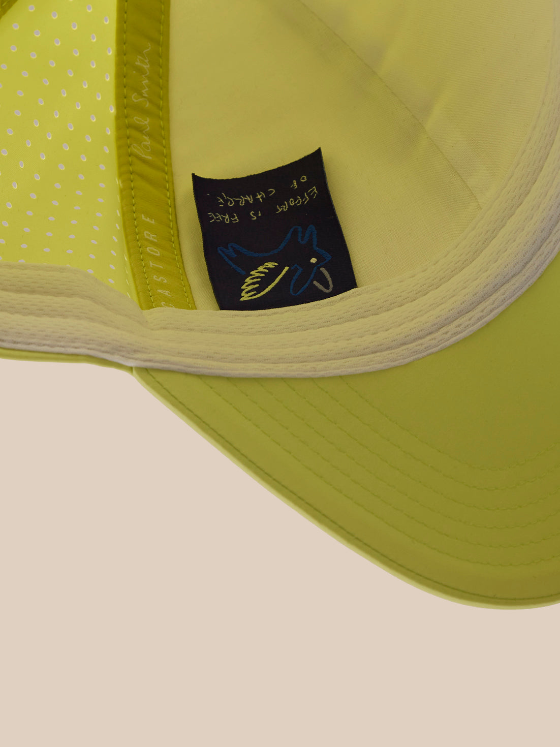 Close-up of a green cap with a brand label on a beige background