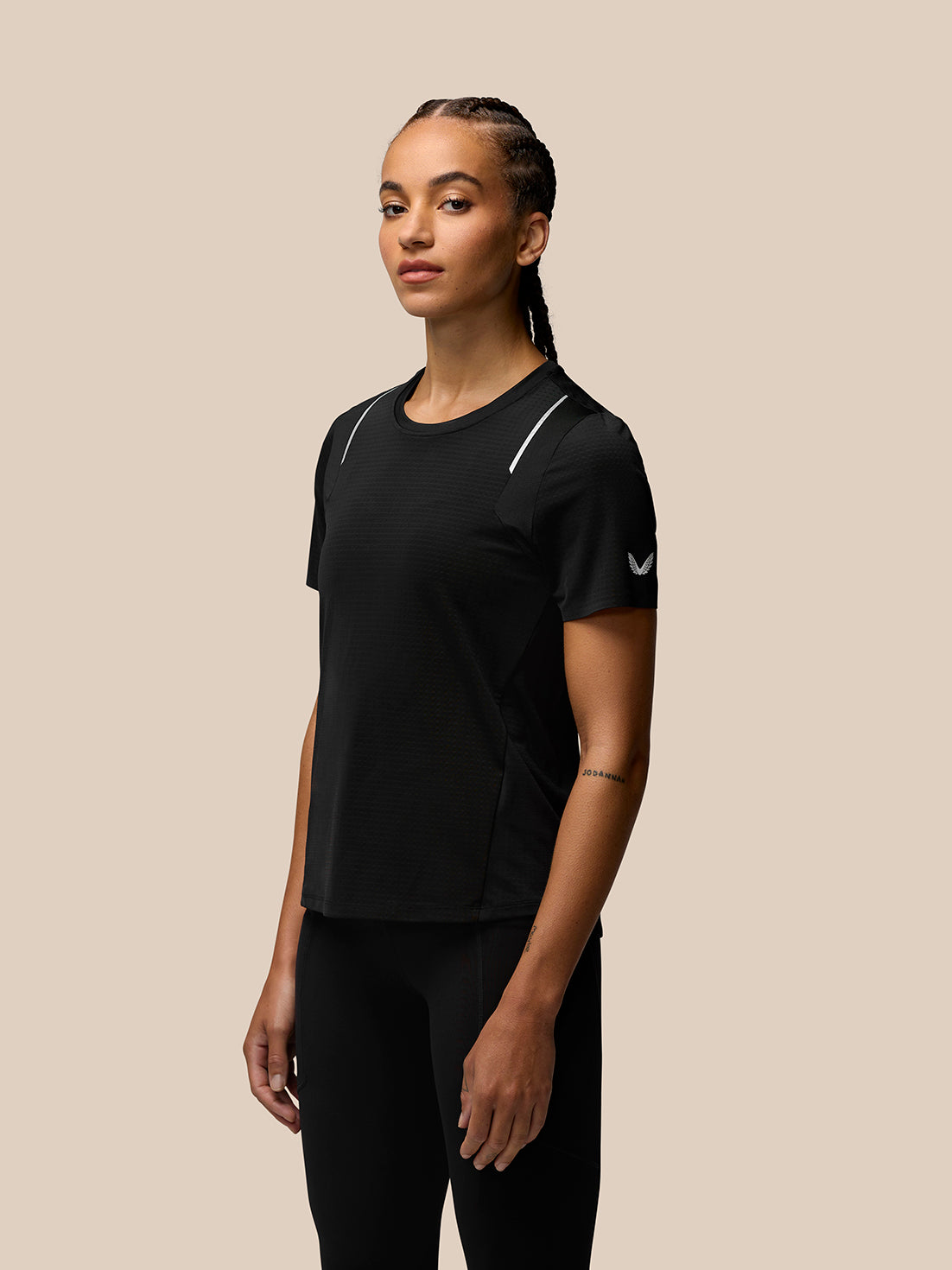 Female model in black Apex Aeromesh Training T Shirt with white shoulder piping and sleeve logo.
